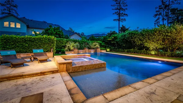 a backyard of a house with table and chairs under an umbrella