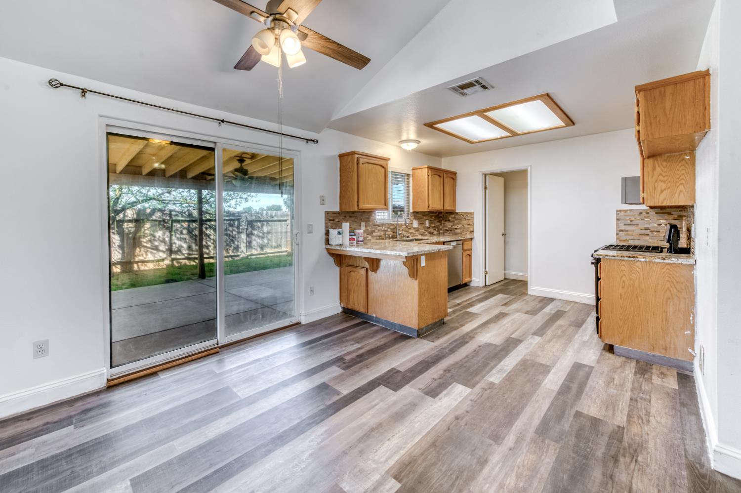 19650 Oakhill Road Madera, CA 93638 - Photo 12 of 49 a kitchen with stainless steel appliances granite countertop a stove oven and a table with wooden floor