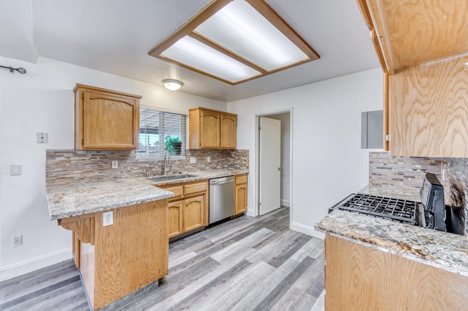 19650 Oakhill Road Madera, CA 93638 - Photo 13 of 49 a kitchen with a stove sink and cabinets