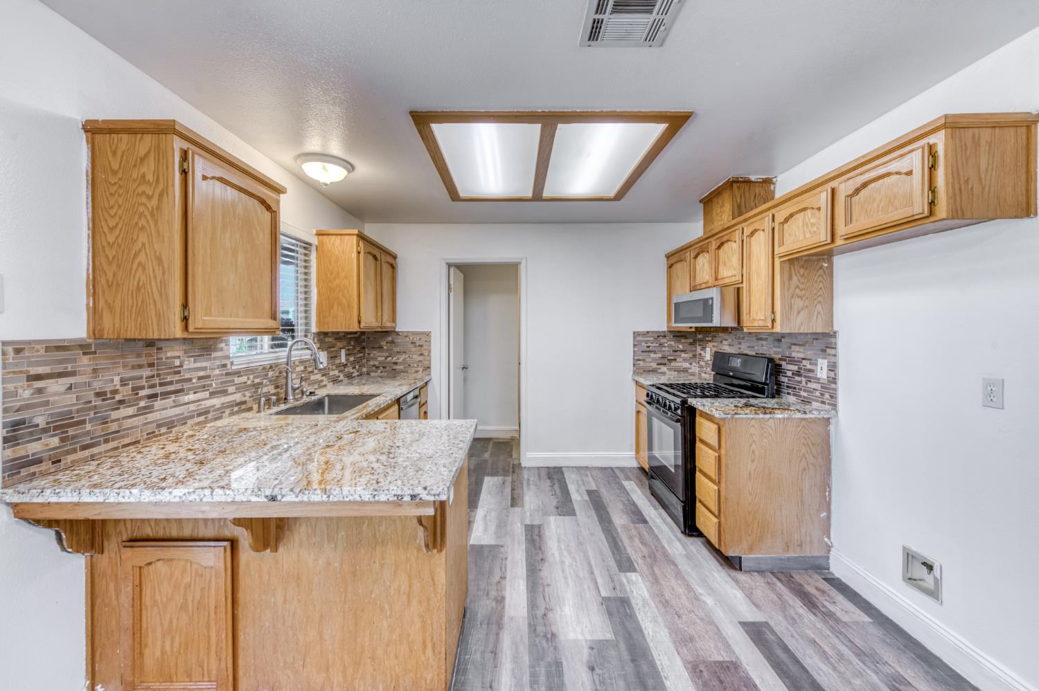 19650 Oakhill Road Madera, CA 93638 - Photo 15 of 49 a kitchen with a stove a sink and a refrigerator