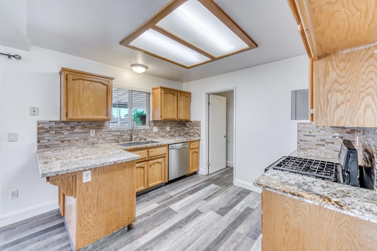19650 Oakhill Road Madera, CA 93638 - Photo 16 of 49 a kitchen with a stove sink and cabinets