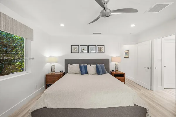 a large bedroom with a bed and a painting on the wall