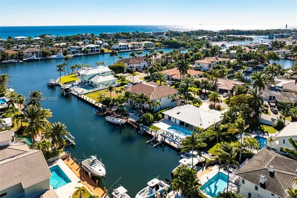 an aerial view of water body with boats and residential houses with outdoor space