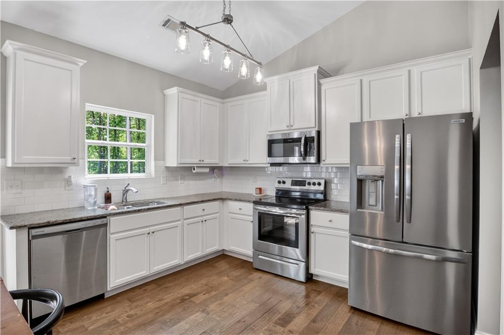 584 Tuxedo Drive Commerce, GA 30530 - Photo 11 of 30 a kitchen with white cabinets stainless steel appliances and window