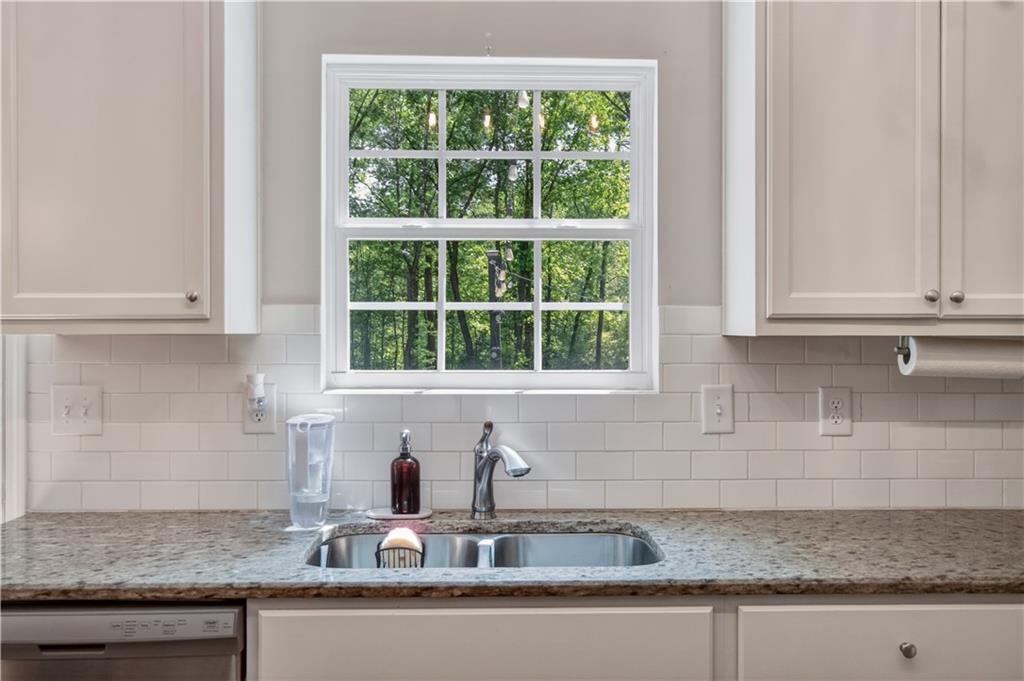 584 Tuxedo Drive Commerce, GA 30530 - Photo 12 of 30 a kitchen with granite countertop a sink a window and cabinets