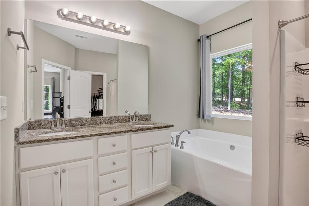 584 Tuxedo Drive Commerce, GA 30530 - Photo 15 of 30 a bathroom with a granite countertop sink mirror bathtub and next