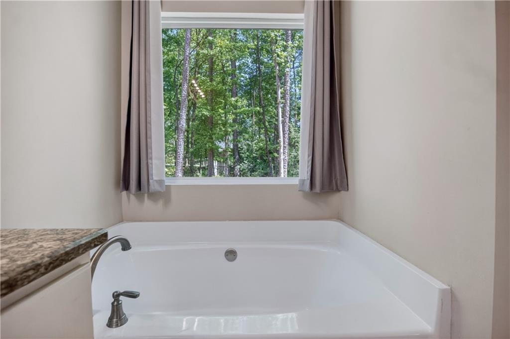 584 Tuxedo Drive Commerce, GA 30530 - Photo 16 of 30 a white bath tub sitting in a bathroom next to a window