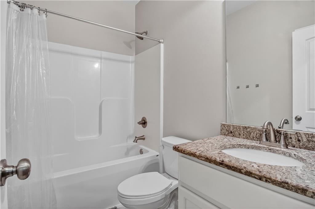 584 Tuxedo Drive Commerce, GA 30530 - Photo 18 of 30 a bathroom with a granite countertop sink toilet and shower