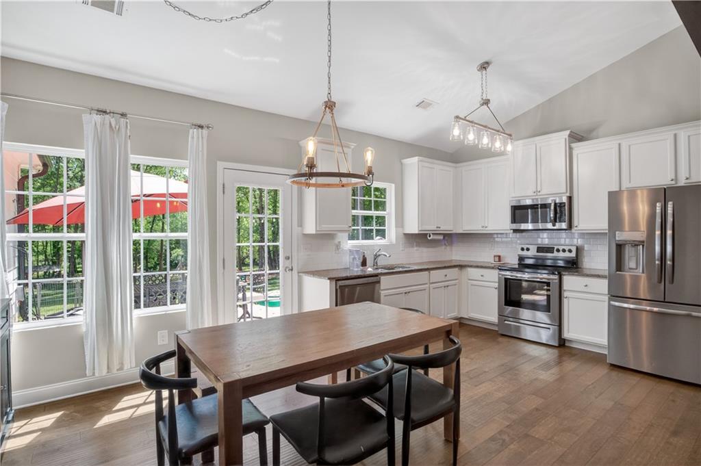 584 Tuxedo Drive Commerce, GA 30530 - Photo 6 of 30 a kitchen with stainless steel appliances granite countertop a stove a refrigerator a kitchen island a sink cabinets and a dining table