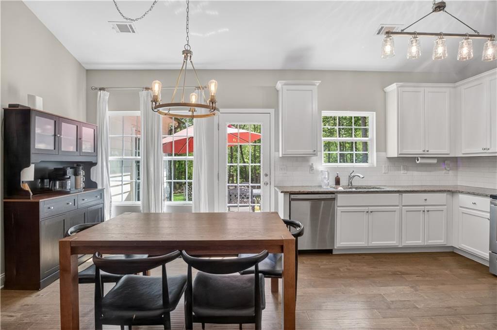 584 Tuxedo Drive Commerce, GA 30530 - Photo 8 of 30 a kitchen with stainless steel appliances granite countertop a kitchen island hardwood floor sink stove dining table and chairs
