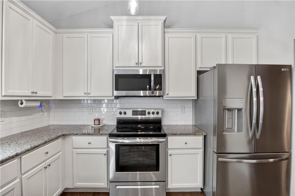 584 Tuxedo Drive Commerce, GA 30530 - Photo 10 of 30 a kitchen with white cabinets and stainless steel appliances