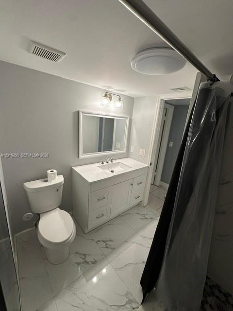 10975 Southwest 107th Street, Unit 110 Miami, FL 33176 - Photo 11 of 26 a bathroom with a toilet sink and mirror