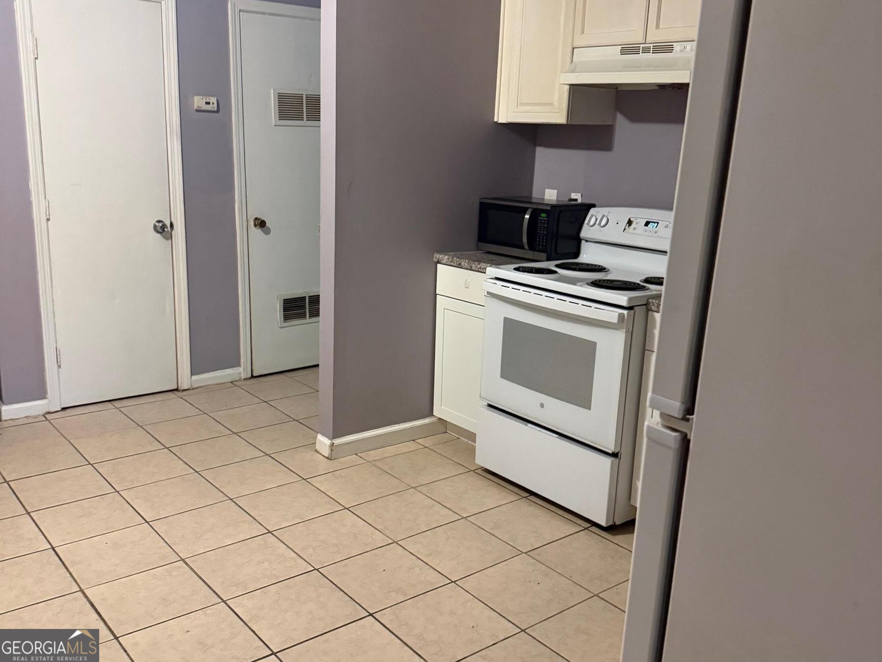 7055 Swift Street Lithonia, GA 30058 - Photo 5 of 9 a kitchen with a stove and a microwave