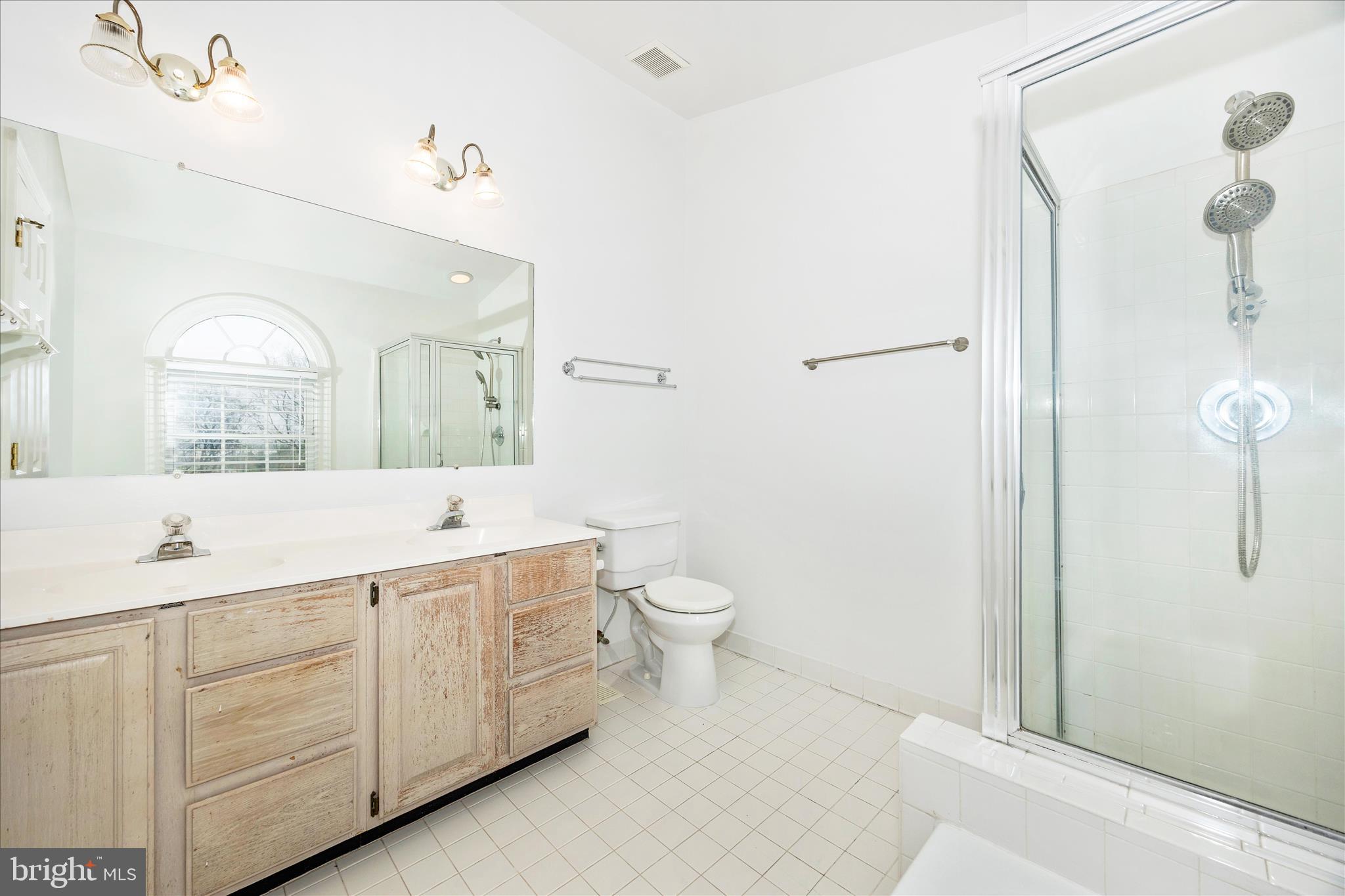 5577 Rivendell Place Frederick, MD 21703 - Photo 24 of 51 a spacious bathroom with a double vanity sink toilet mirror and shower