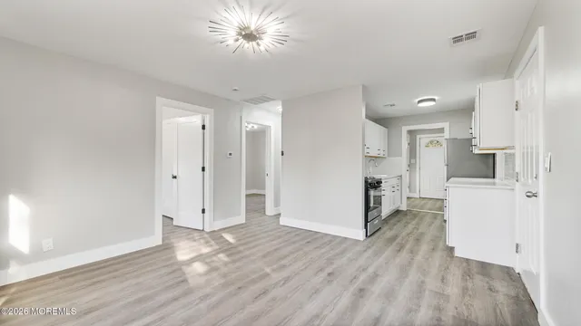 a view of a kitchen with wooden floor and a kitchen