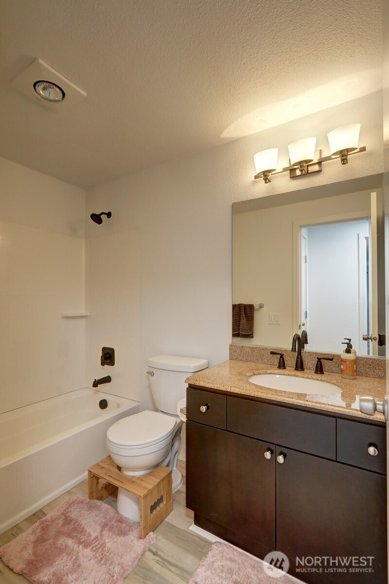 9806 28th Avenue Southwest, Unit A201 Seattle, WA 98126 - Photo 12 of 14 a bathroom with a sink a toilet and a bathtub