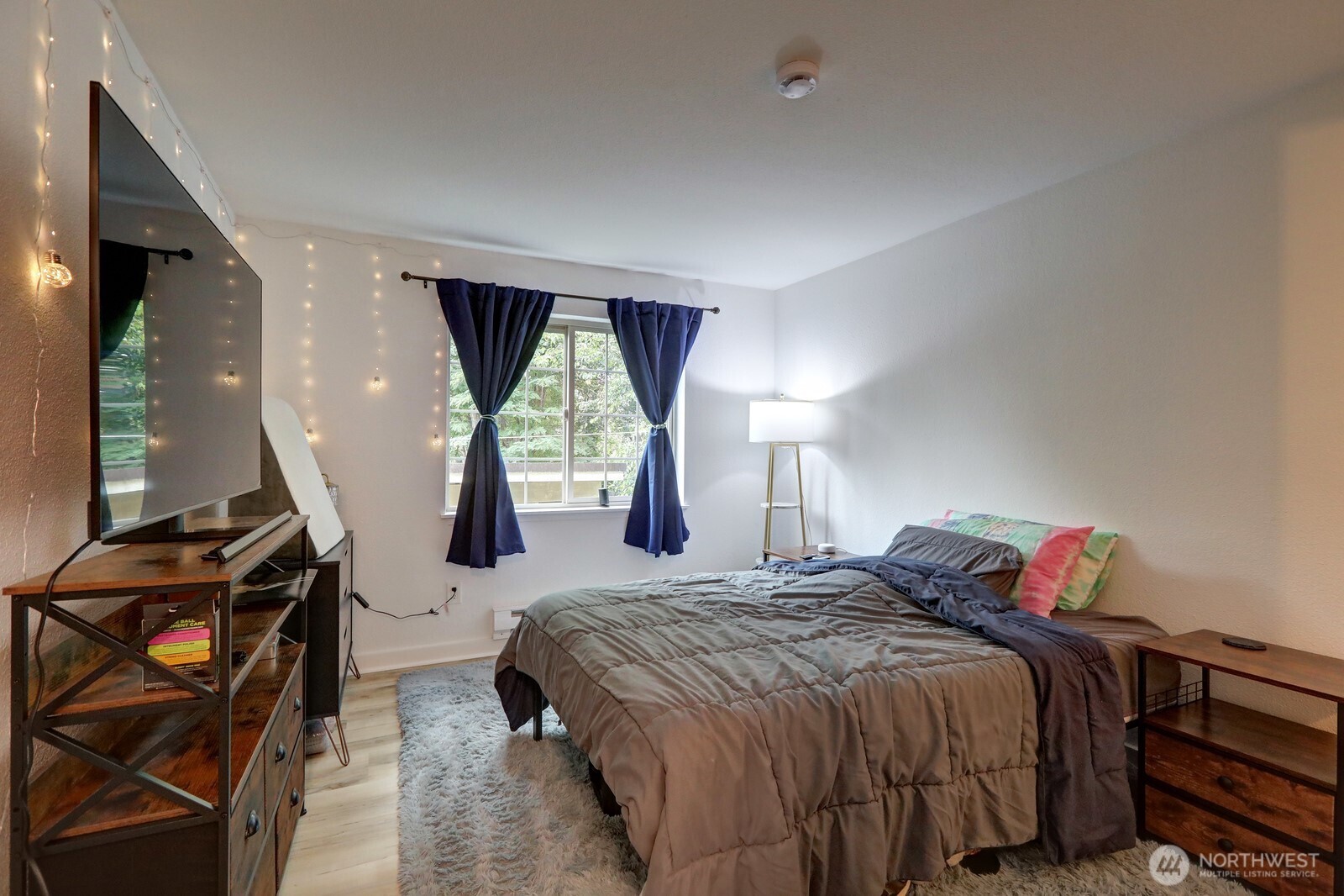 9806 28th Avenue Southwest, Unit A201 Seattle, WA 98126 - Photo 3 of 14 a bedroom with a bed and wooden floor