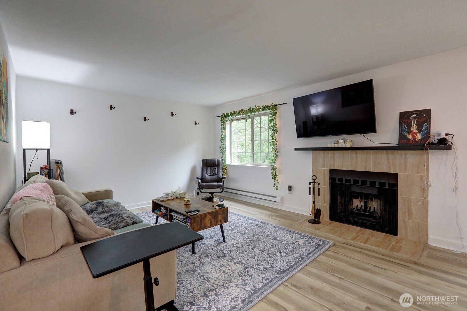 9806 28th Avenue Southwest, Unit A201 Seattle, WA 98126 - Photo 4 of 14 a living room with furniture a flat screen tv and a fireplace