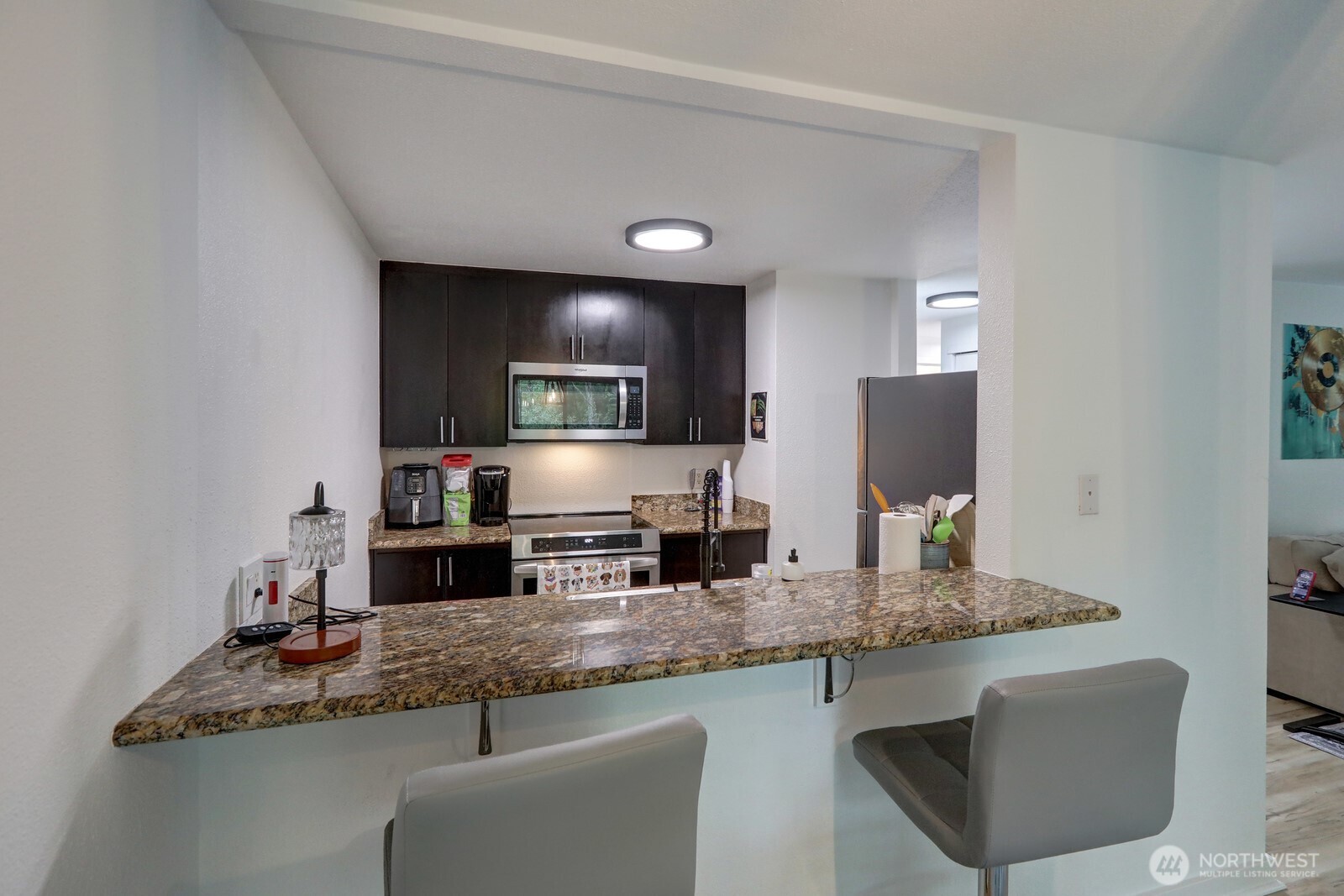 9806 28th Avenue Southwest, Unit A201 Seattle, WA 98126 - Photo 7 of 14 a kitchen with granite countertop stainless steel appliances a sink stove and refrigerator