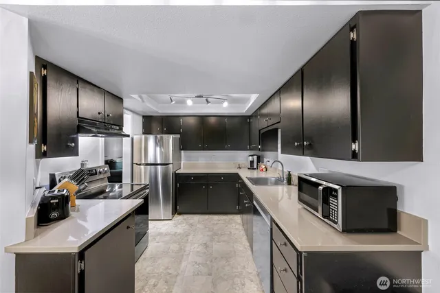 a kitchen with stainless steel appliances a sink stove and refrigerator