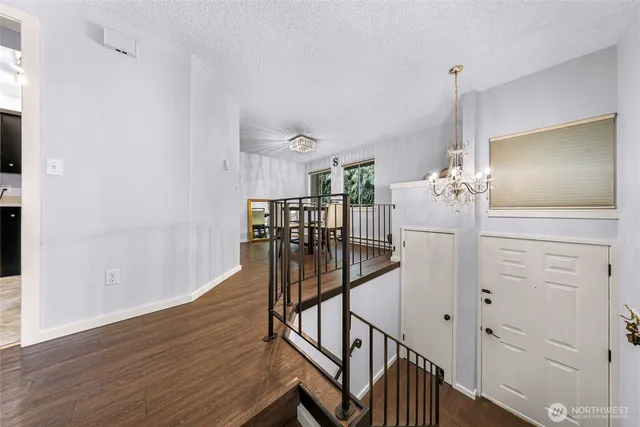a view of a hallway with wooden floor and stairs