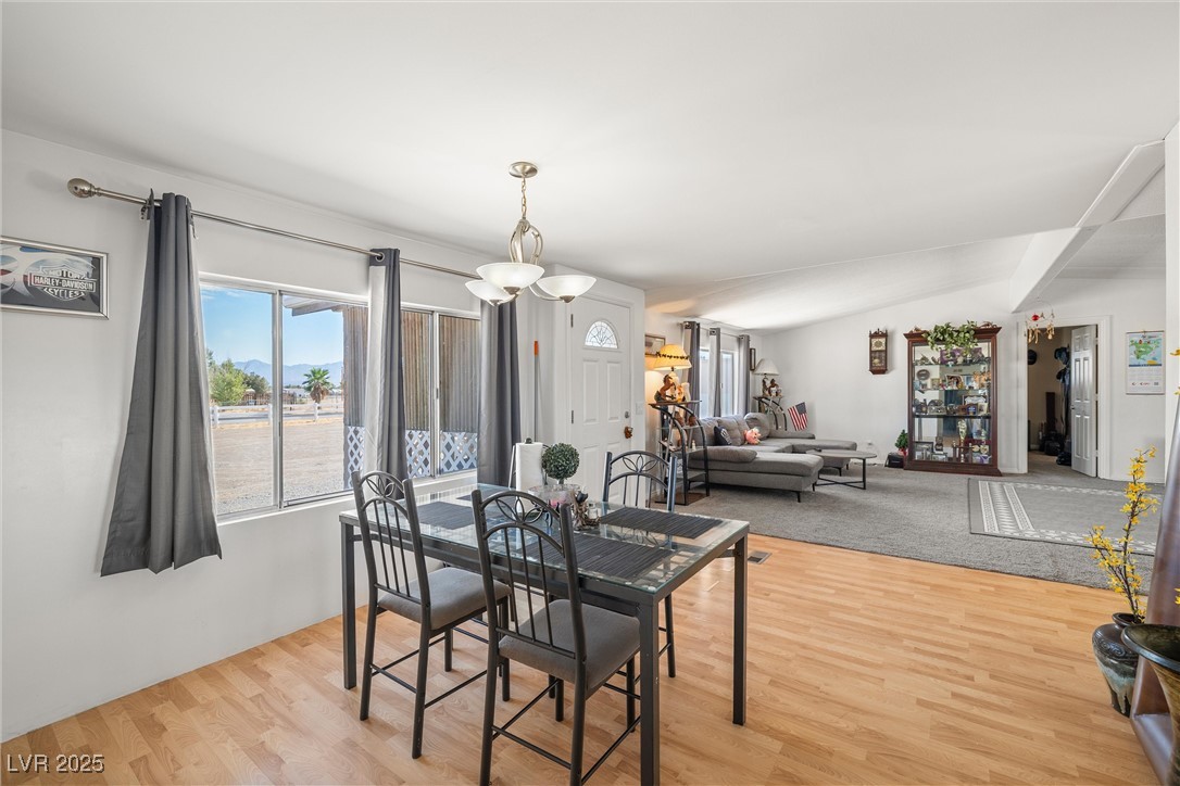 3581 West Dyer Road Pahrump, NV 89048 - Photo 15 of 31 Dining space featuring light wood-style floors and vaulted ceiling