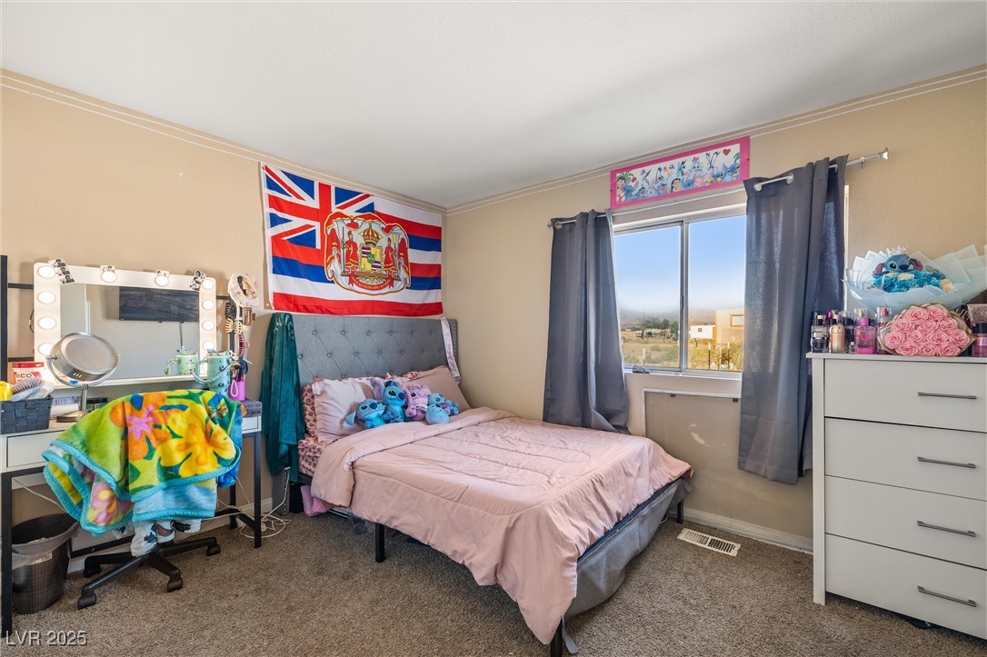 3581 West Dyer Road Pahrump, NV 89048 - Photo 21 of 31 Bedroom featuring crown molding and carpet