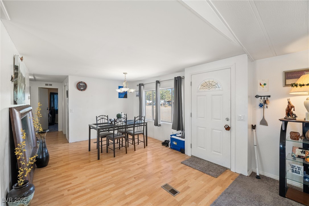 3581 West Dyer Road Pahrump, NV 89048 - Photo 5 of 31 Dining space featuring light wood finished floors and a chandelier