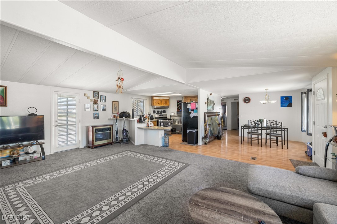 3581 West Dyer Road Pahrump, NV 89048 - Photo 7 of 31 Living room with light colored carpet and a chandelier