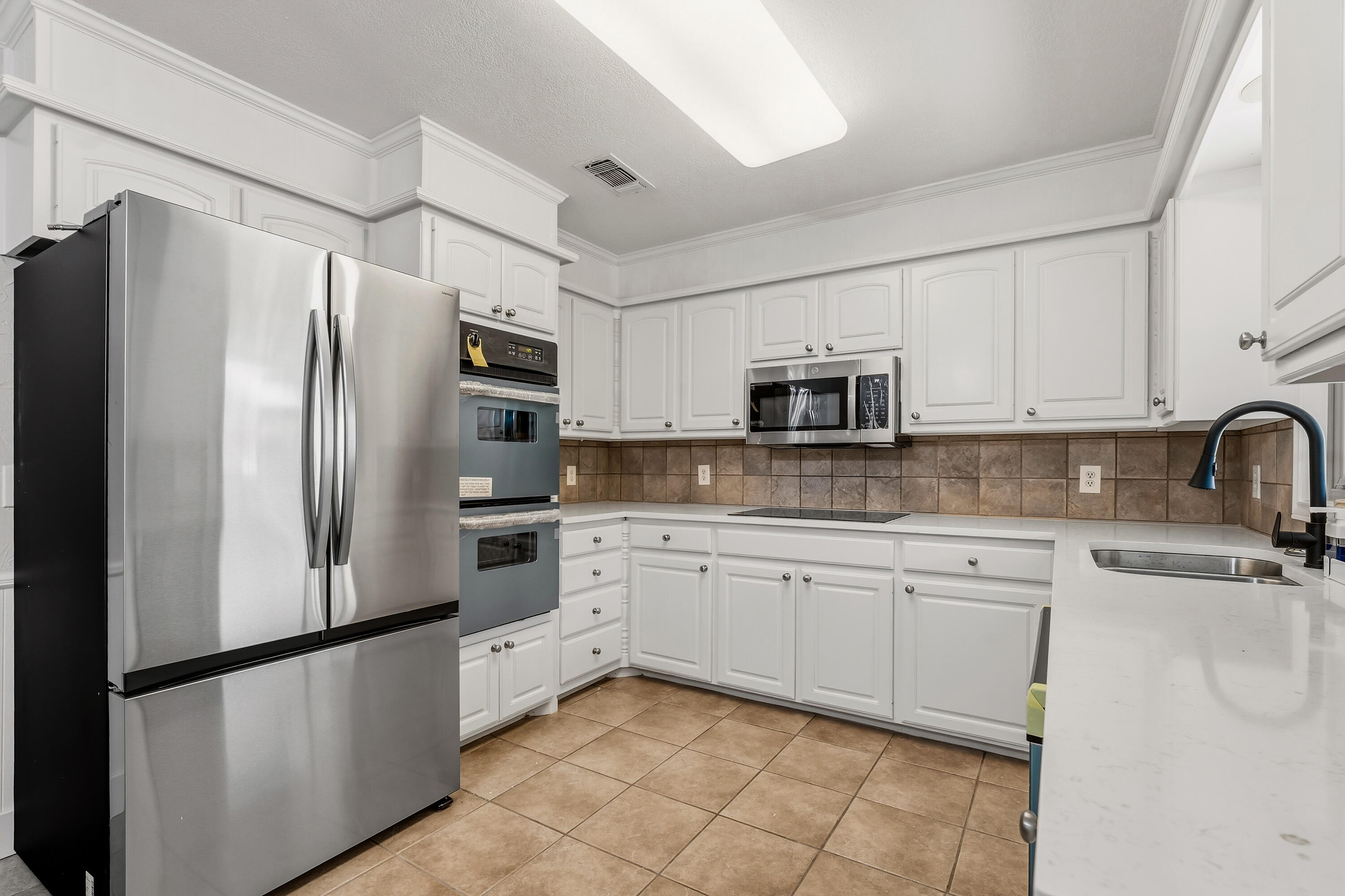5002 94th Street Lubbock, TX 79424 - Photo 11 of 30 a kitchen with stainless steel appliances granite countertop a refrigerator sink and microwave