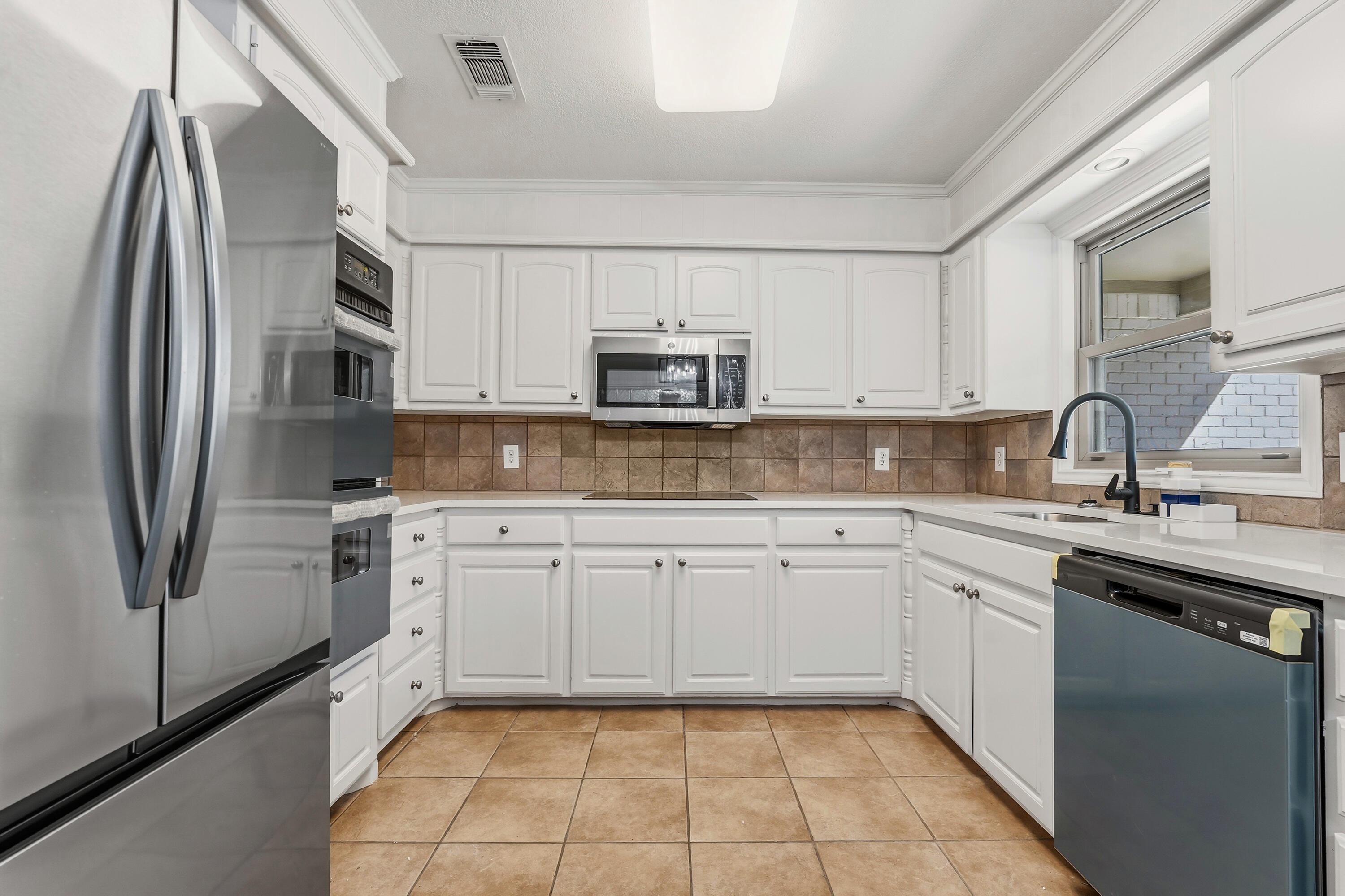 5002 94th Street Lubbock, TX 79424 - Photo 12 of 30 a kitchen with stainless steel appliances granite countertop a refrigerator sink and microwave