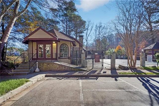 a view of a house with backyard and wooden fence
