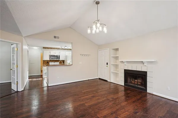 a view of a livingroom with wooden floor and a fireplace