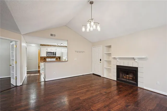a view of a livingroom with wooden floor and a fireplace