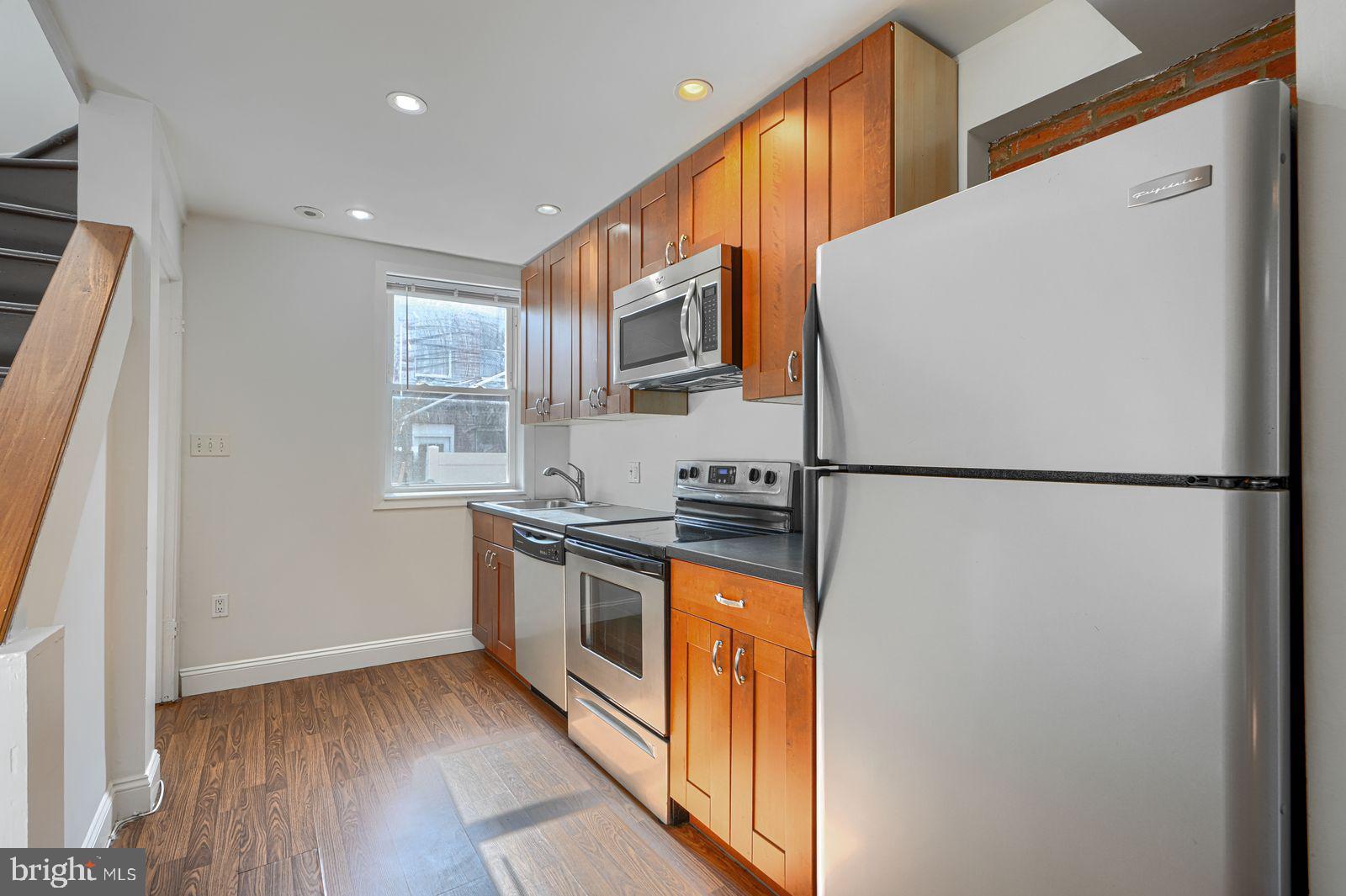 1026 Patapsco Street Baltimore, MD 21230 - Photo 6 of 24 a kitchen with stainless steel appliances granite countertop a refrigerator a stove a sink and a microwave