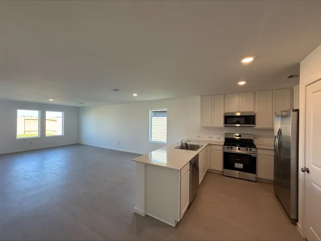 a kitchen with granite countertop a refrigerator and a sink