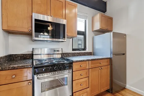 a kitchen with stainless steel appliances granite countertop a stove microwave and sink