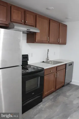 a kitchen with stainless steel appliances granite countertop a stove a refrigerator and a sink