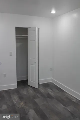 an empty room with wooden floor and closet