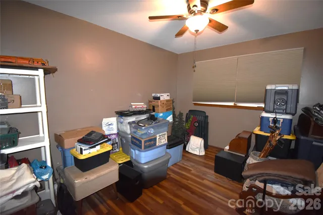 a living room with furniture and a dining table with bookshelf