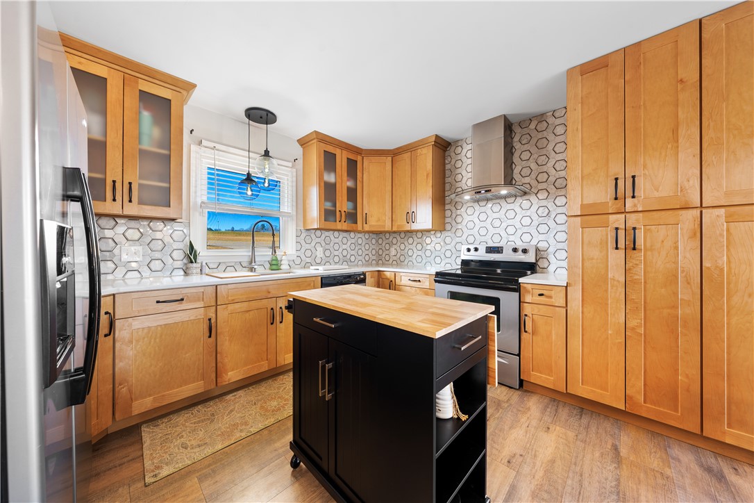 3067 Anderson Highway Liberty, SC 29657 - Photo 10 of 32 This modern kitchen features warm wooden cabinetry and a chic geometric tile backsplash.