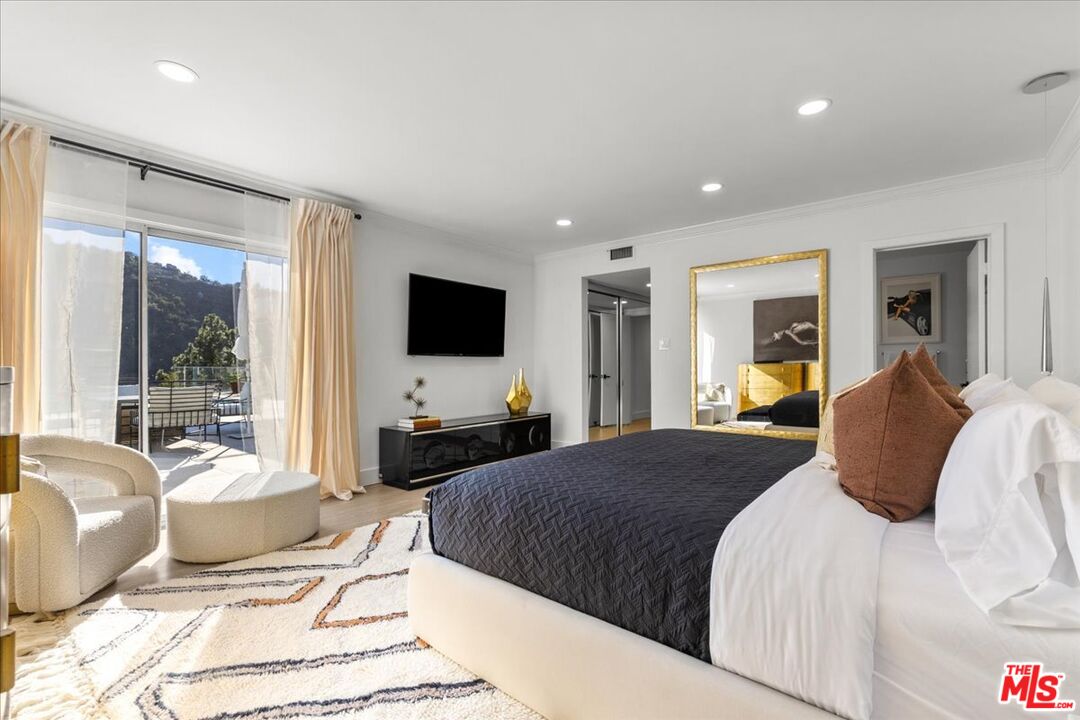 1650 Clear View Drive Beverly Hills, CA 90210 - Photo 12 of 31 a bedroom with a bed and glass windows