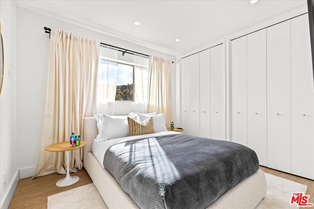 1650 Clear View Drive Beverly Hills, CA 90210 - Photo 15 of 31 a bed sitting in a spacious bedroom next to a window