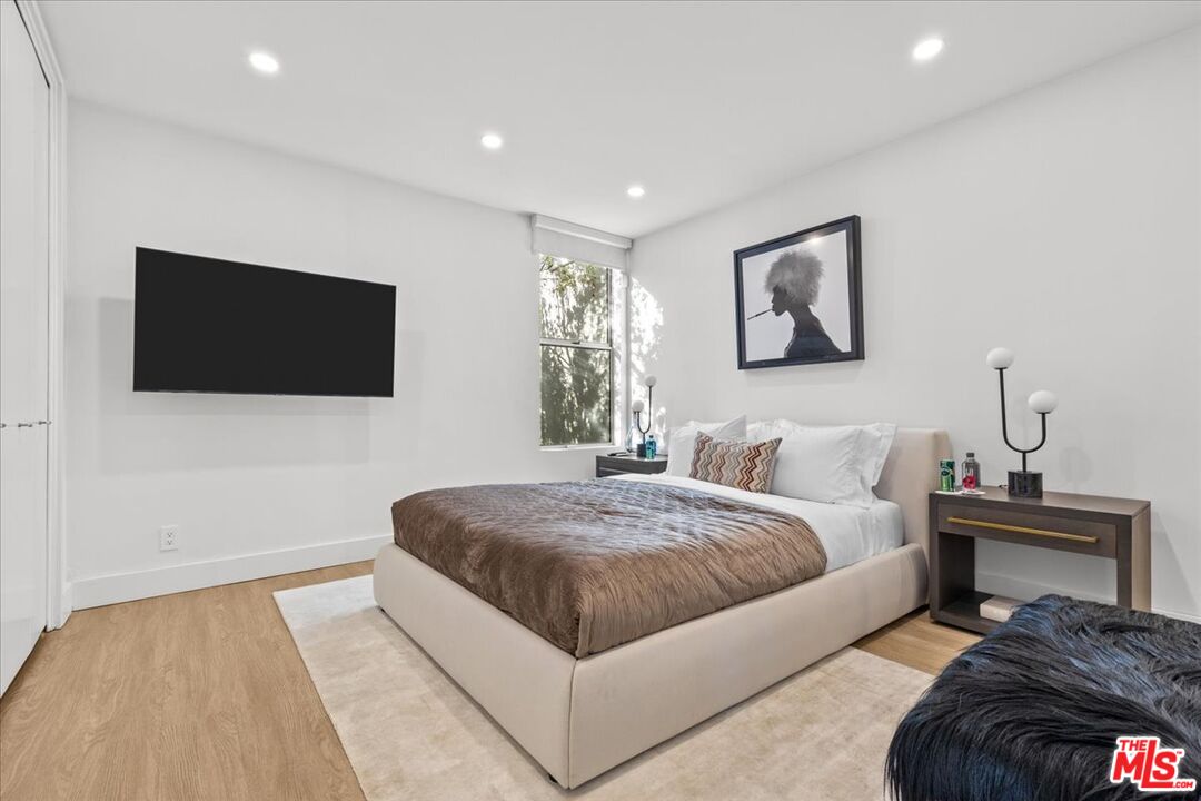 1650 Clear View Drive Beverly Hills, CA 90210 - Photo 17 of 31 a spacious bedroom with a bed and a flat screen tv