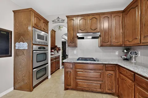 a kitchen with stainless steel appliances granite countertop a stove and a refrigerator