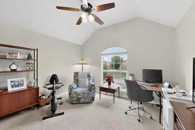 a view of a workspace with furniture and a window