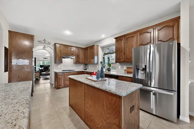 a kitchen with kitchen island granite countertop stainless steel appliances cabinets a sink and a counter top space