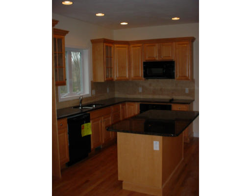 3 Devonshire Road Amesbury, MA 01913 - Photo 4 of 8 a kitchen with kitchen island granite countertop a sink and a stove top oven with wooden floor