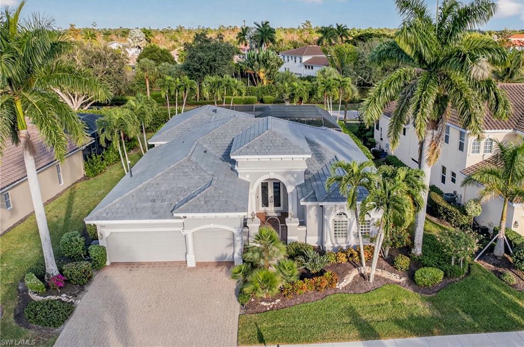 an aerial view of a house with a yard and a large tree