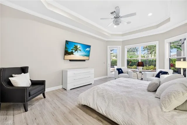 a bedroom with a bed large window and a flat screen tv